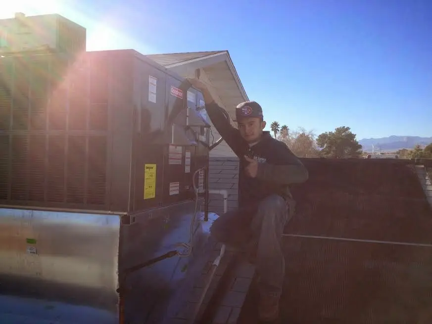 HVAC technician performing AC Tune-Up on a rooftop unit in Haverhill